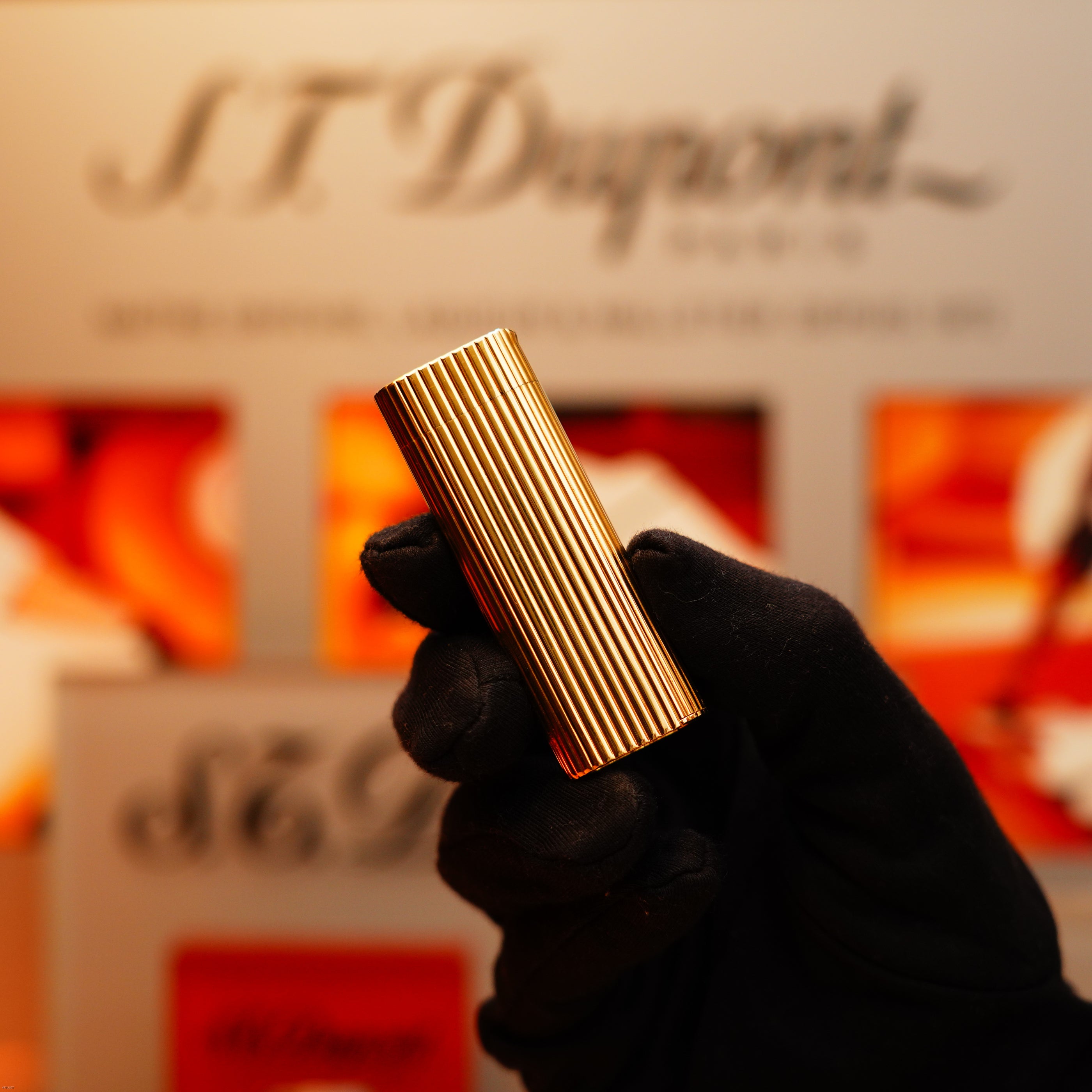 A gloved hand holds a Vintage 1970 Extremely Rare Cartier Solid 18k Gold Vertical Line Heavy Lighter with 750 hallmarks, available from KirbyAllison.com.