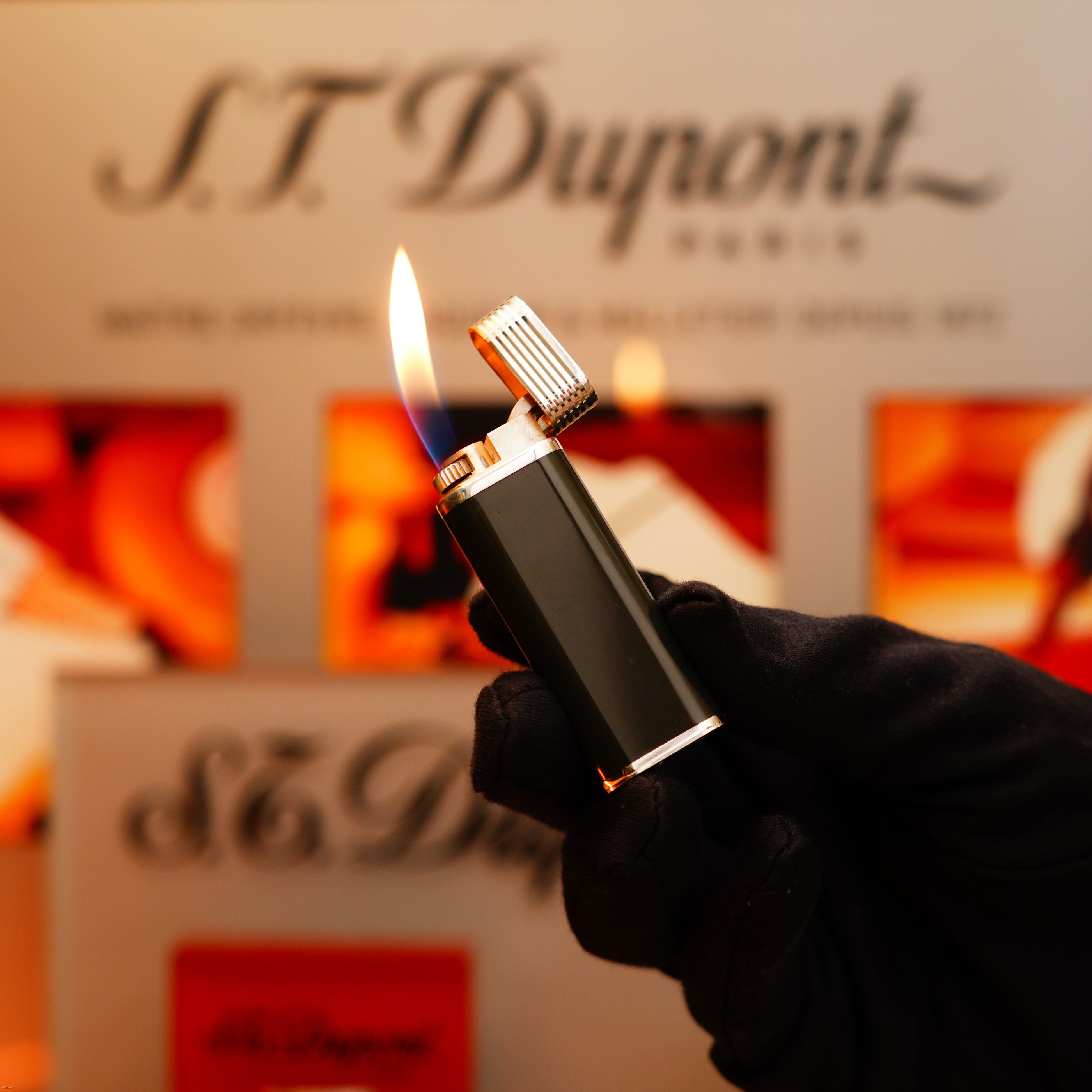 A gloved hand holds and ignites a Vintage 1970 Extremely Rare Cartier Solid 925 Sterling Silver Natural Full Dark Green Lacquer Rare Lighter from KirbyAllison.com in front of a blurred display.