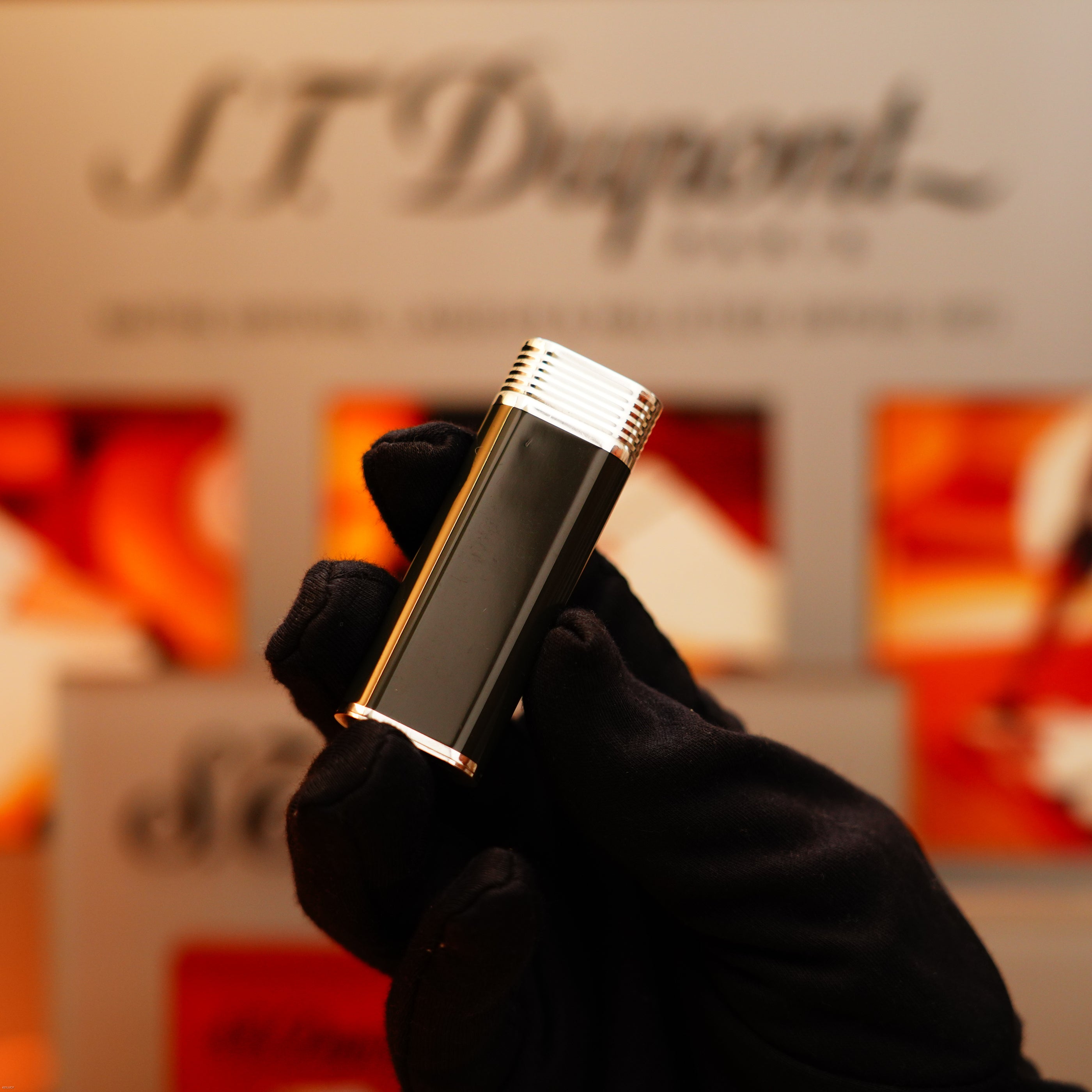 A gloved hand holds a Vintage 1970 Extremely Rare Cartier Solid 925 Sterling Silver Natural Full Dark Green Lacquer Rare Lighter from KirbyAllison.com in front of a blurred S.T. Dupont sign.