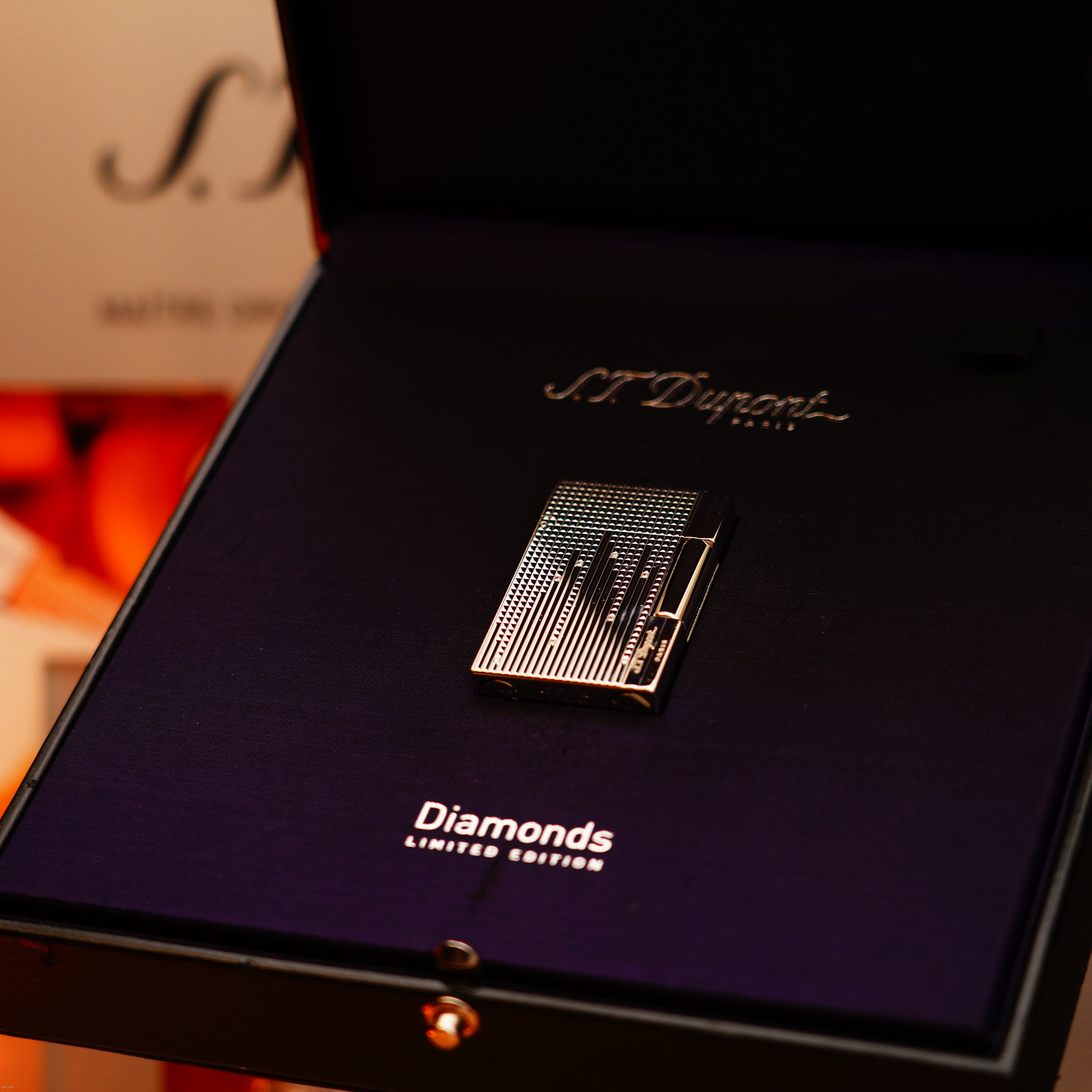 A Vintage 2005 S.T. Dupont Gatsby Diamond Drops Heavy Platinum Limited Edition Lighter with 16 natural diamonds, presented in a black display case featuring "Diamonds Limited Edition" inside the box.