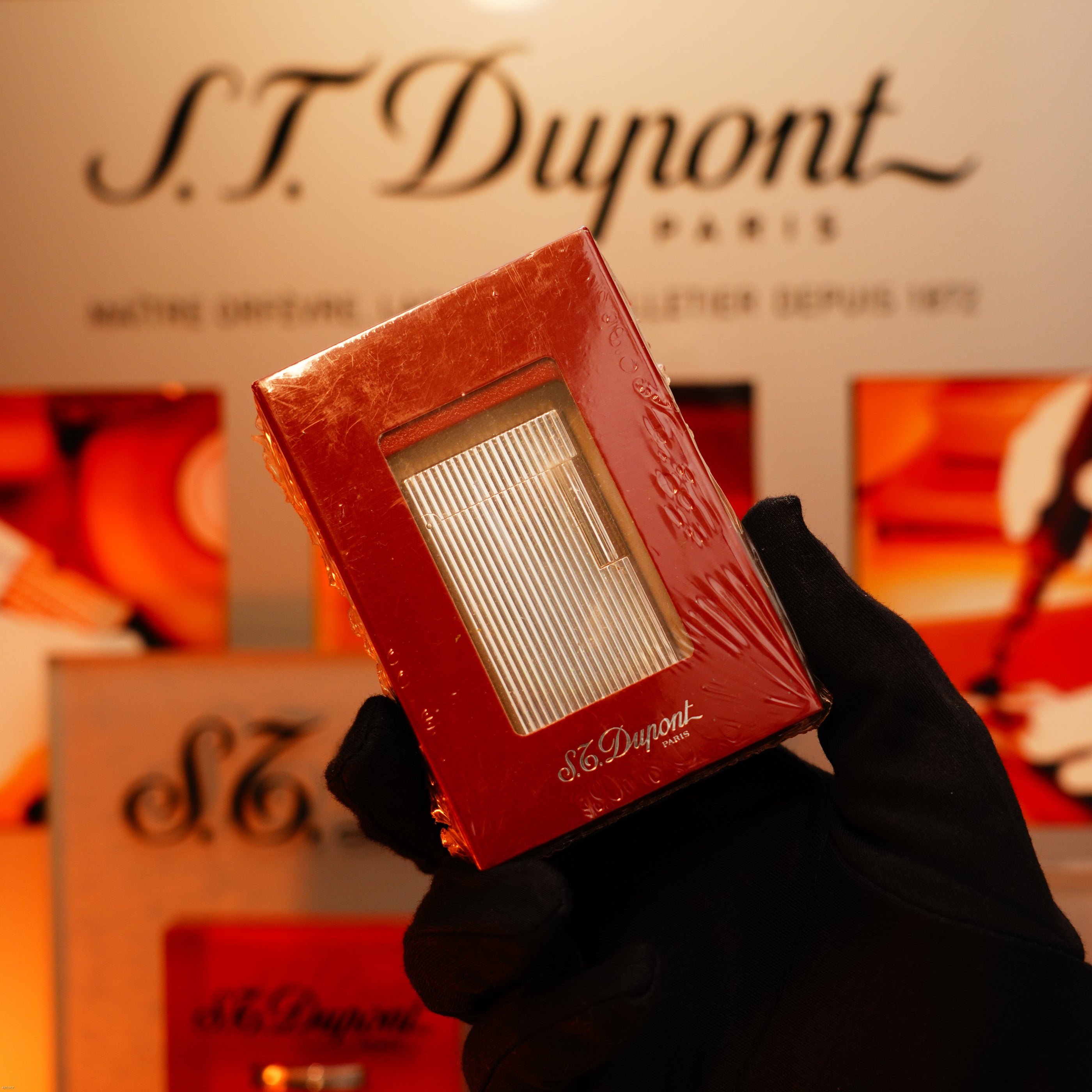 A gloved hand holds a boxed Vintage 1990 St Dupont Heavy Silver Vertical Ligne rare sealed lighter by Lucy Lighter, showcased before a display embodying timeless style and quality.