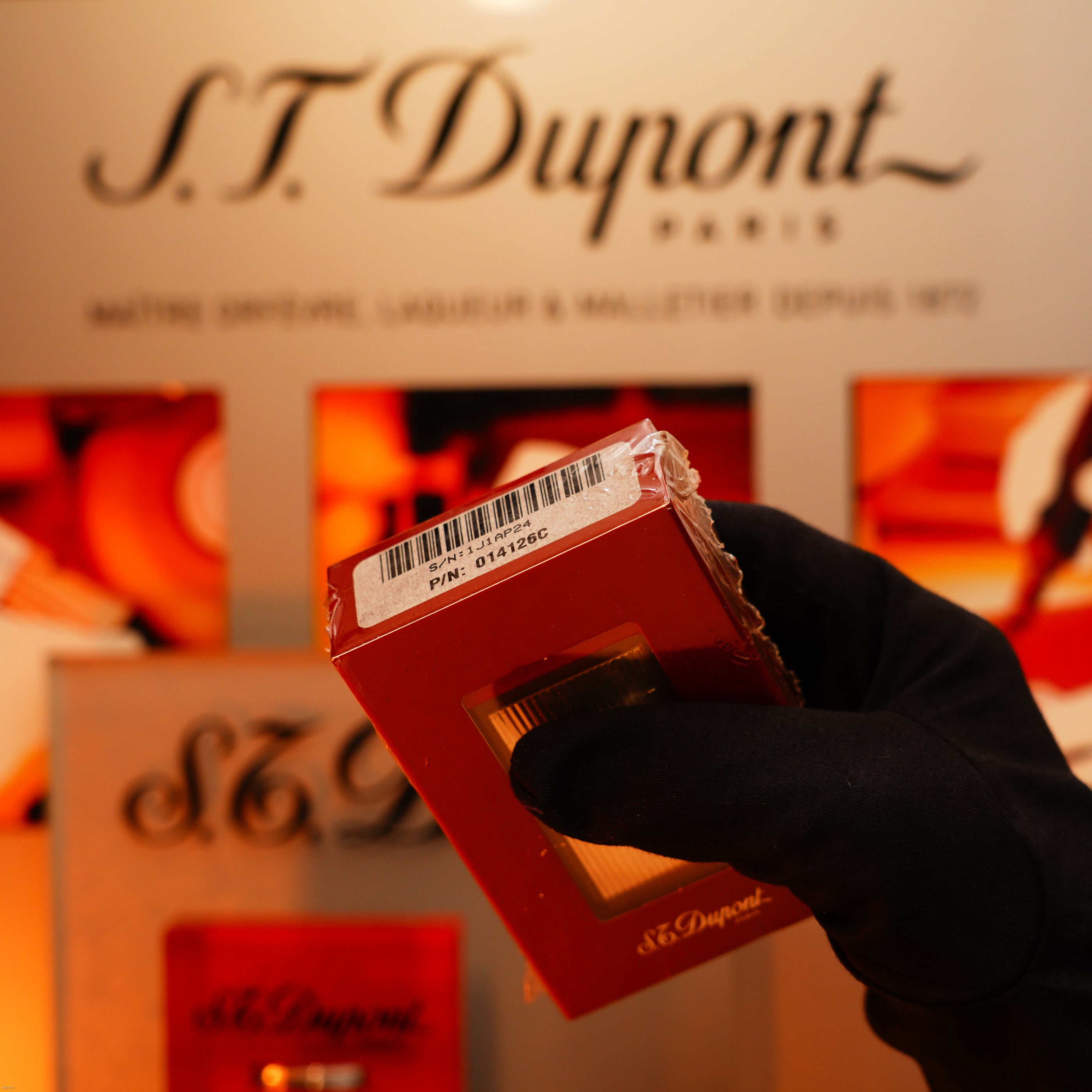 A gloved hand holds a red Lucy Lighter box for the Vintage 1990 St Dupont Heavy Silver Vertical Ligne Rare Sealed Lighter, barcode and PIN: 014126C displayed—a hallmark of collectible luxury.