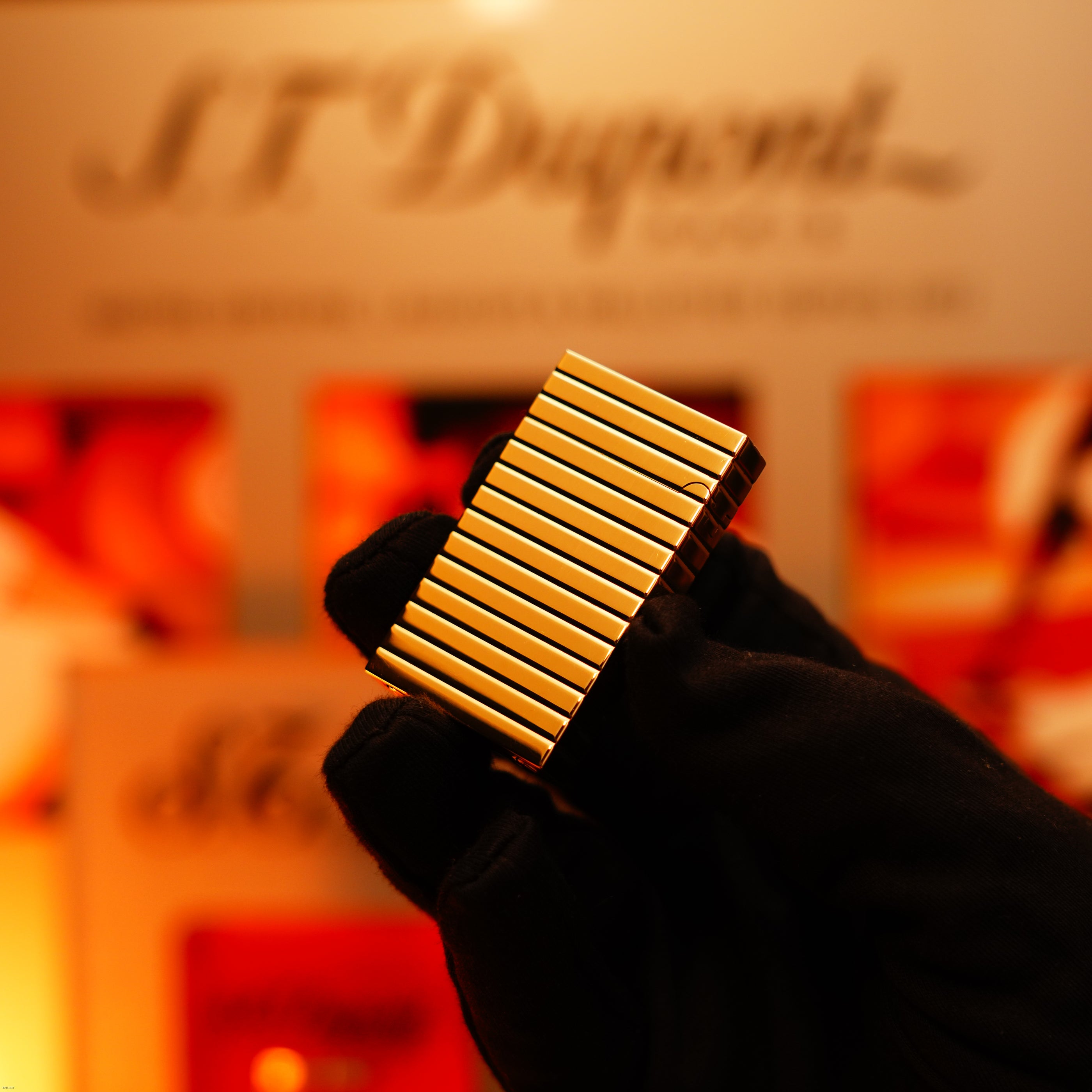 A gloved hand holds the ultra-rare Lucy Lighter Vintage 1970 ST Dupont Lighter—crafted from solid 18K gold, this 1/1 masterpiece exudes luxury and timeless elegance under warm lighting.
