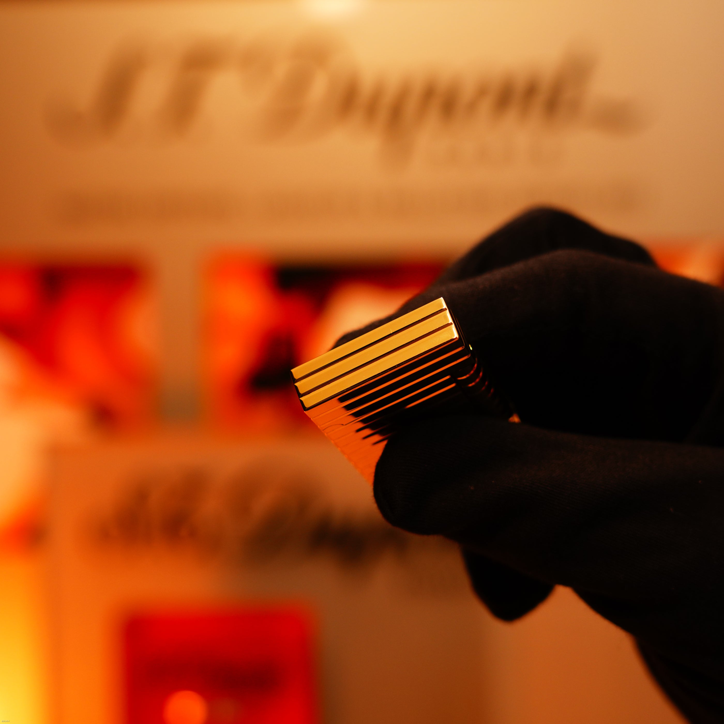 A gloved hand presents the ultra-rare Lucy Lighter Vintage 1970 ST Dupont Lighter—Solid 18K Gold Masterpiece—with warm, blurred signage behind, highlighting its unmatched luxury and authenticity.