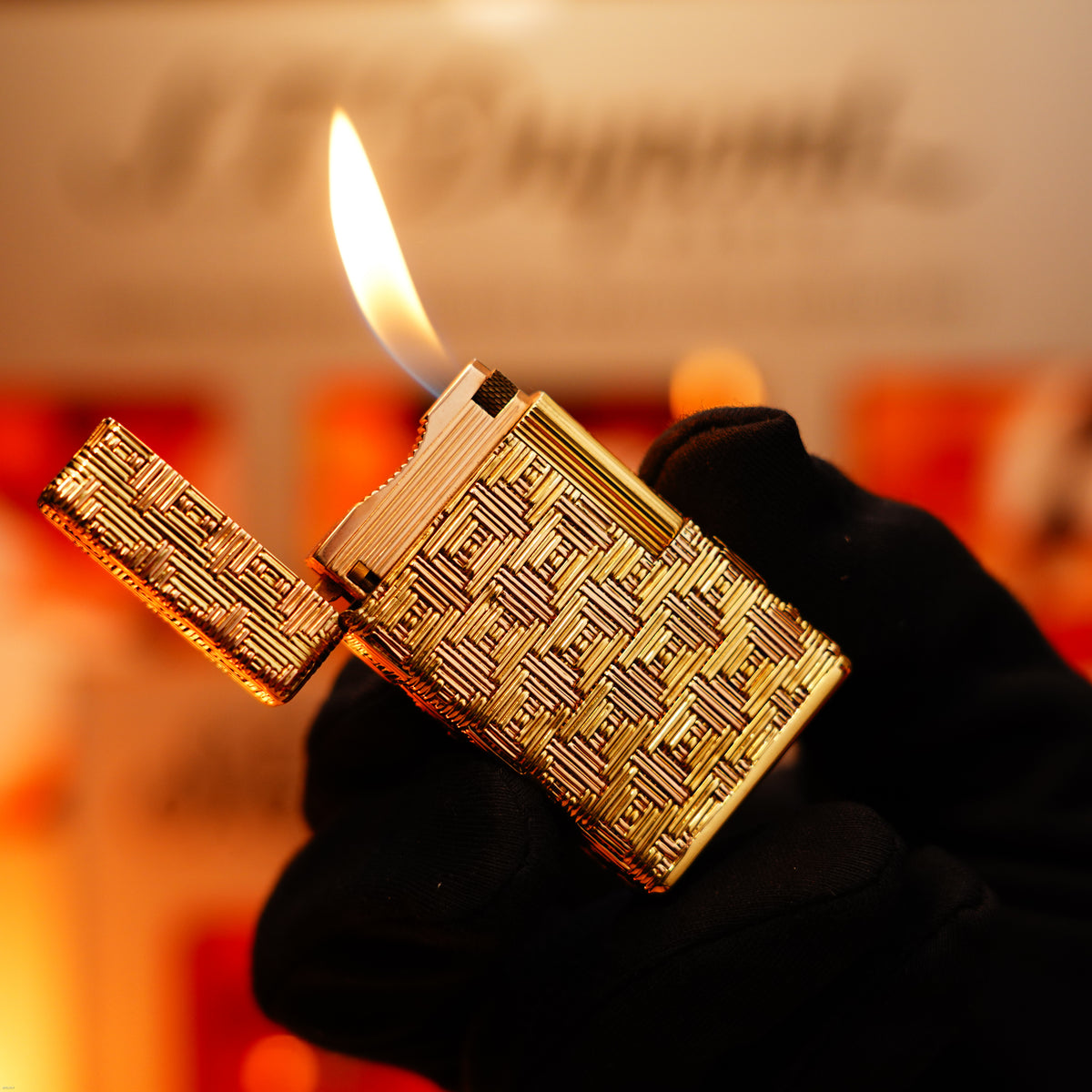 A gloved hand holds a Lucy Lighter Vintage 1960 Extremely Rare 1/1 St Dupont Lighter—solid 18K gold, heavy early edition, 750 hallmarked—with the lid open and flame burning, promising elegance and reliability.