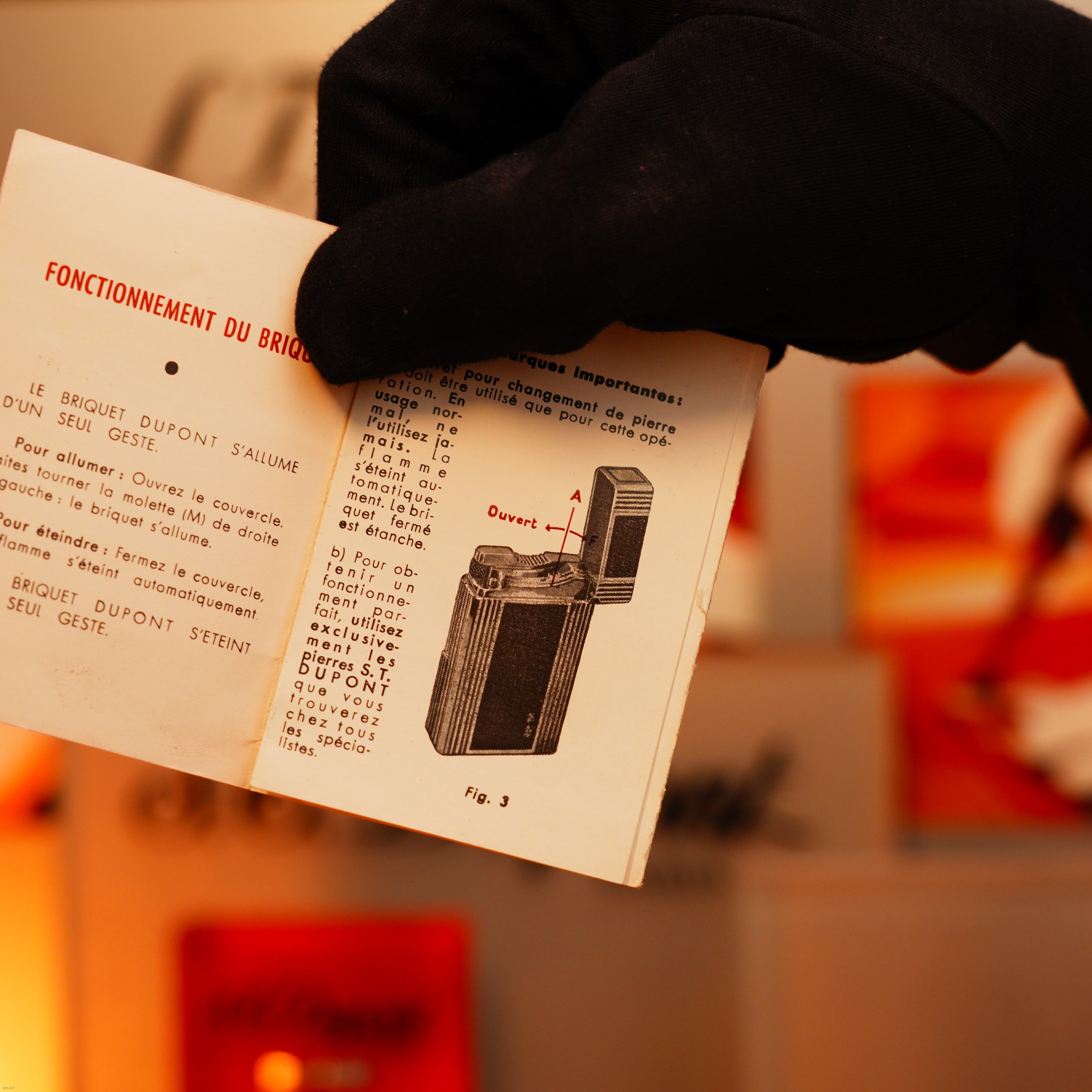 A gloved hand holds an open manual with French text and diagrams for the Lucy Lighter Vintage 1960 Extremely Rare 1/1 St Dupont Lighter, solid 18K gold, early edition, highlighting warranty and defect repair details.