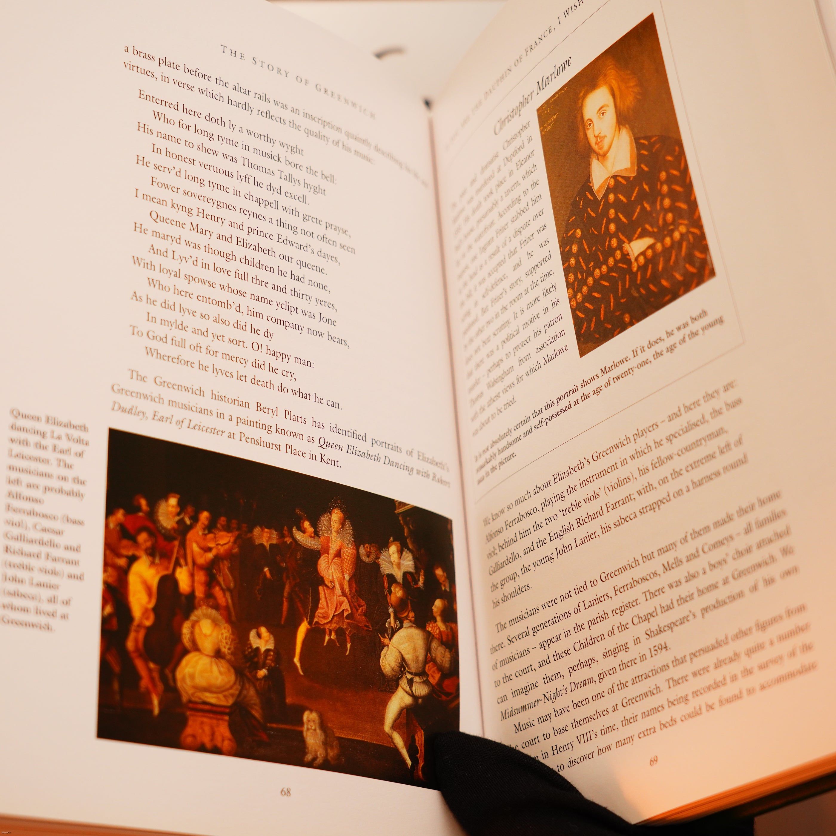 An open book held at its corner reveals text and art of Queen Elizabeth I—its elegant allure reminiscent of the Vintage Extremely Rare Alfred Dunhill Full Set GMT Solid Stainless Steel Lucy Lighter, promising timeless quality and luxury.