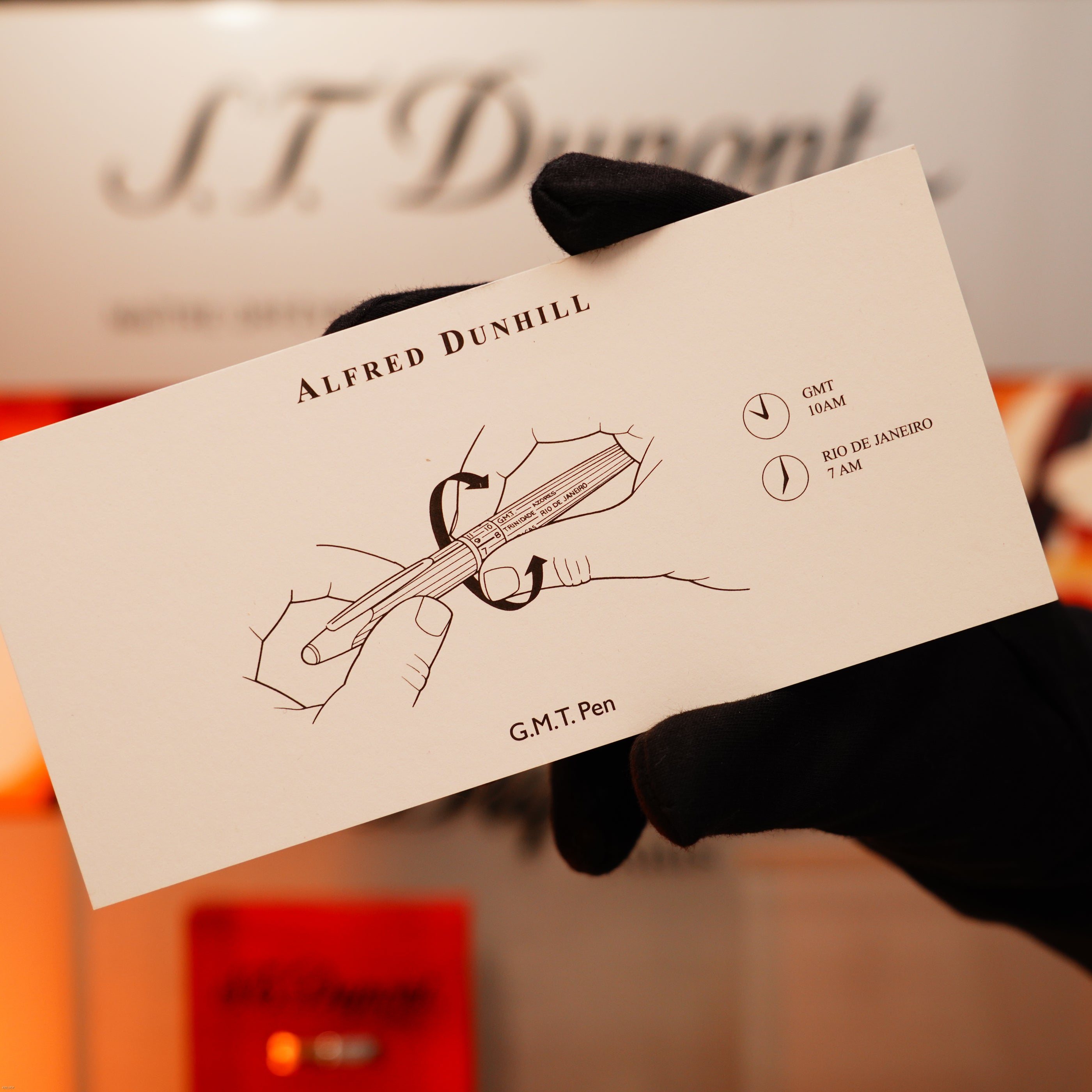 A gloved hand holds a Lucy Lighter Alfred Dunhill GMT card with pen sketch and dual time zones, highlighting the craftsmanship of this Vintage Extremely Rare Alfred Dunhill Full Set in solid stainless steel with signature.