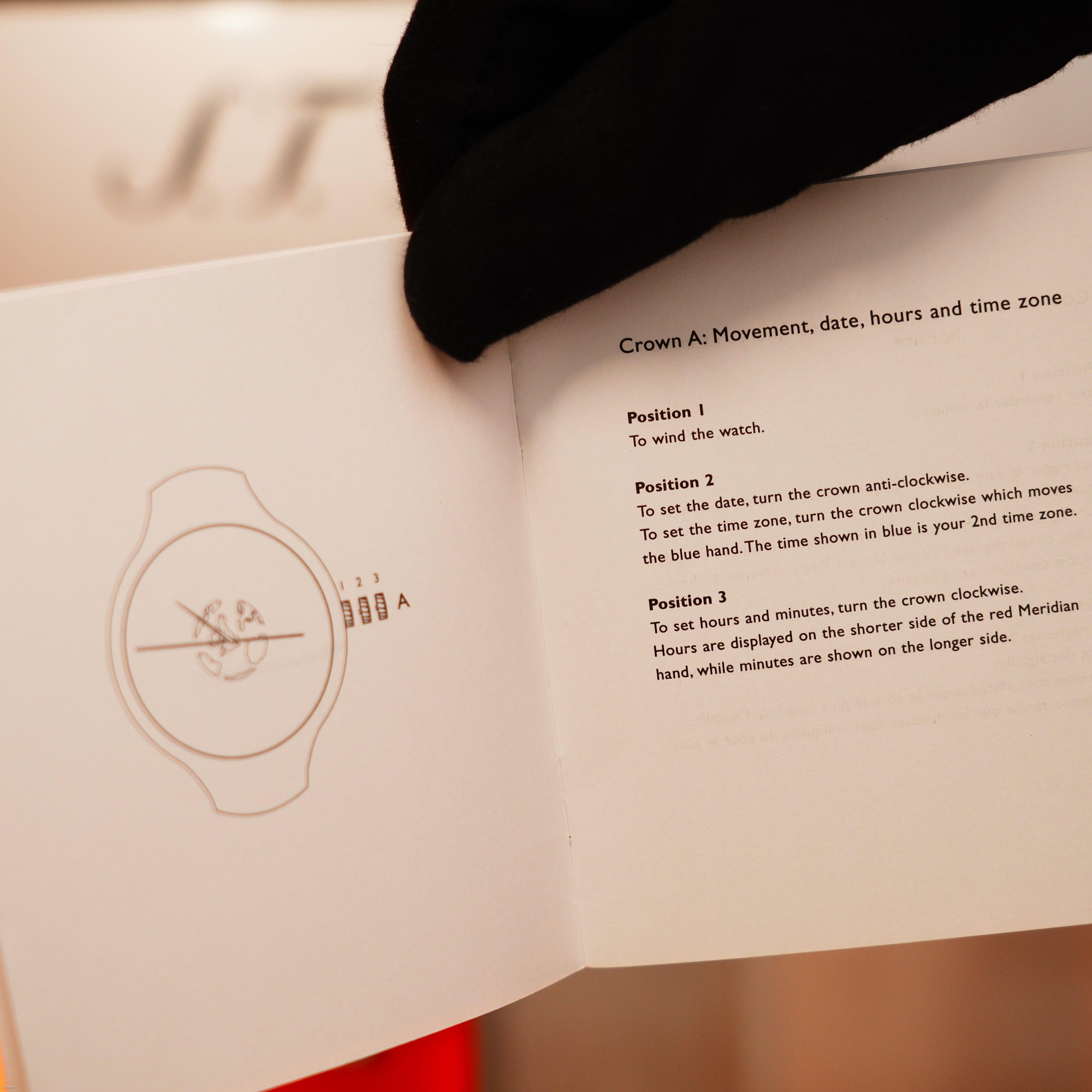 A gloved hand opens the Vintage Extremely Rare Alfred Dunhill Full Set GMT manual by Lucy Lighter, displaying watch illustrations and setup instructions—highlighting quality assurance in every detail.