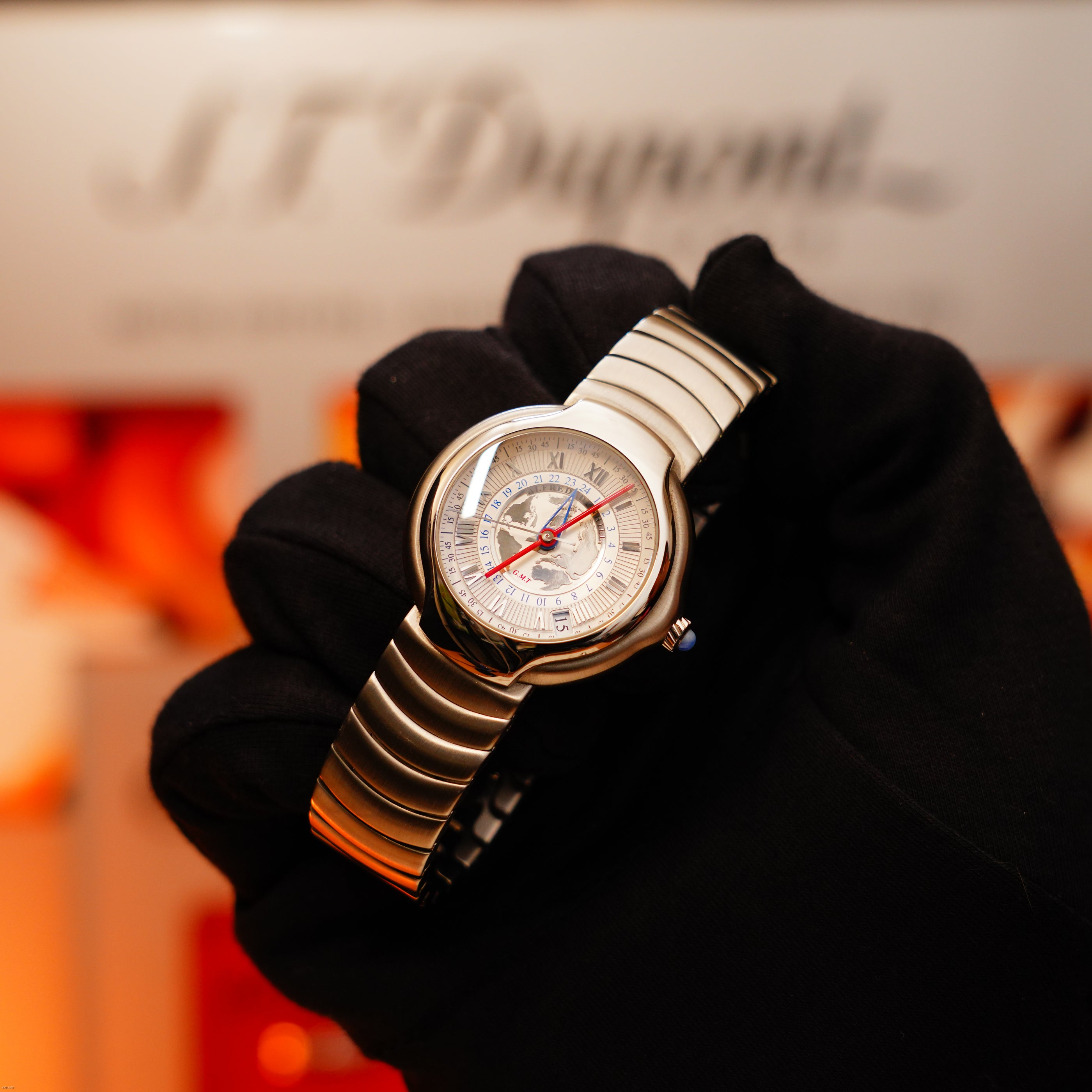 A gloved hand holds the Vintage Extremely Rare Alfred Dunhill Full Set GMT, crafted in solid stainless steel with Alfred Dunhill signature, by Lucy Lighter—a rare timepiece backed by a quality guarantee.