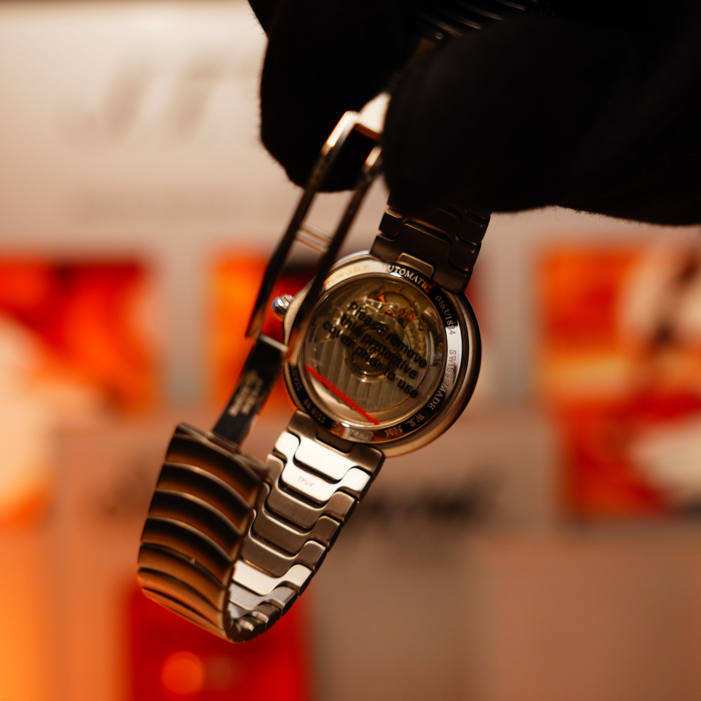 A gloved hand holds the Vintage Extremely Rare Alfred Dunhill Full Set GMT by Lucy Lighter, revealing its transparent case back and internal mechanism—a showcase of fine craftsmanship with a 12-month warranty.