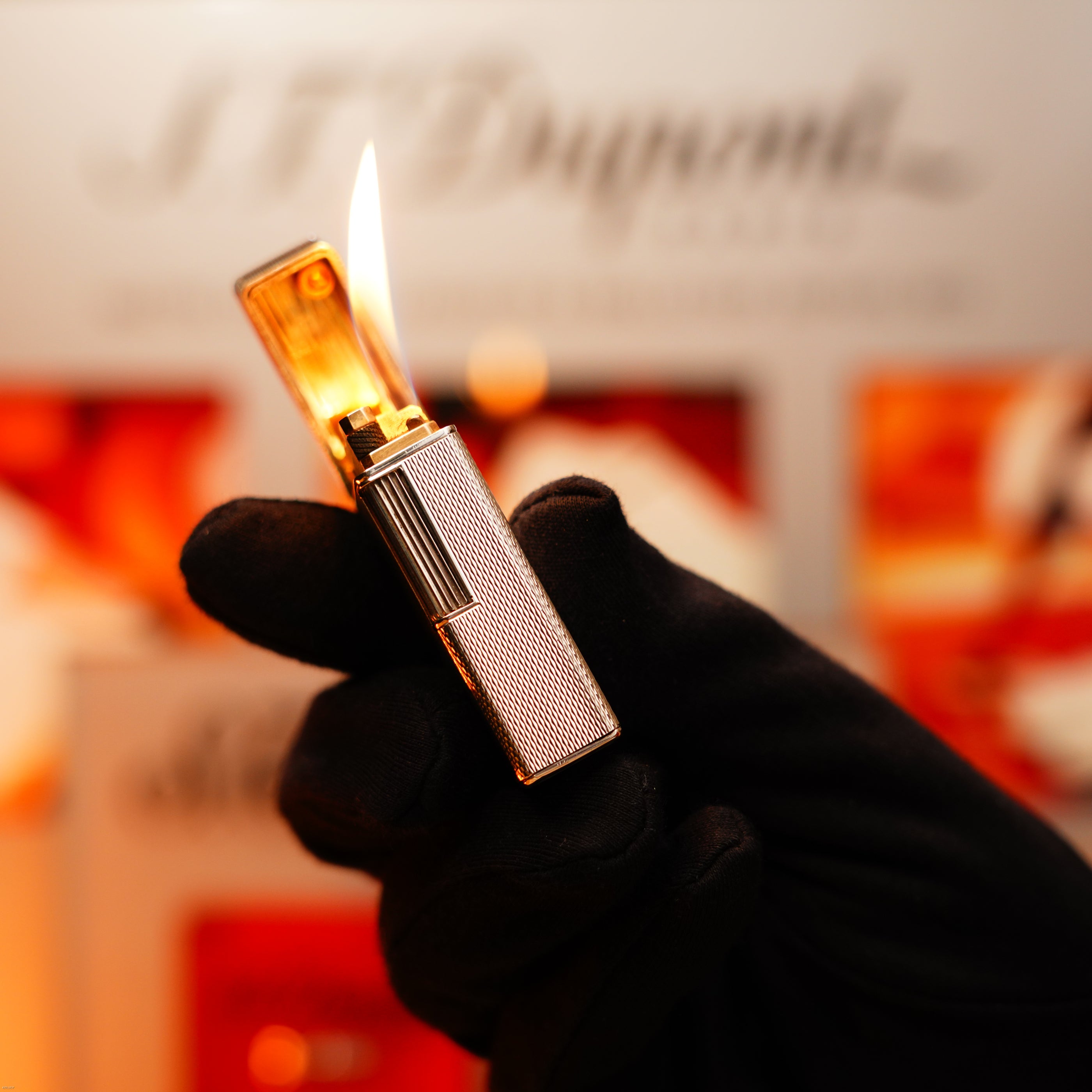A gloved hand holds the Vintage 1970 Extremely Rare 1/1 De St Dupont Solid 925 Sterling Rare Ligne 1 Heavy Barley Pattern Lighter by Lucy Lighter, lit with flame and set against a background highlighting quality and a 12-month warranty.