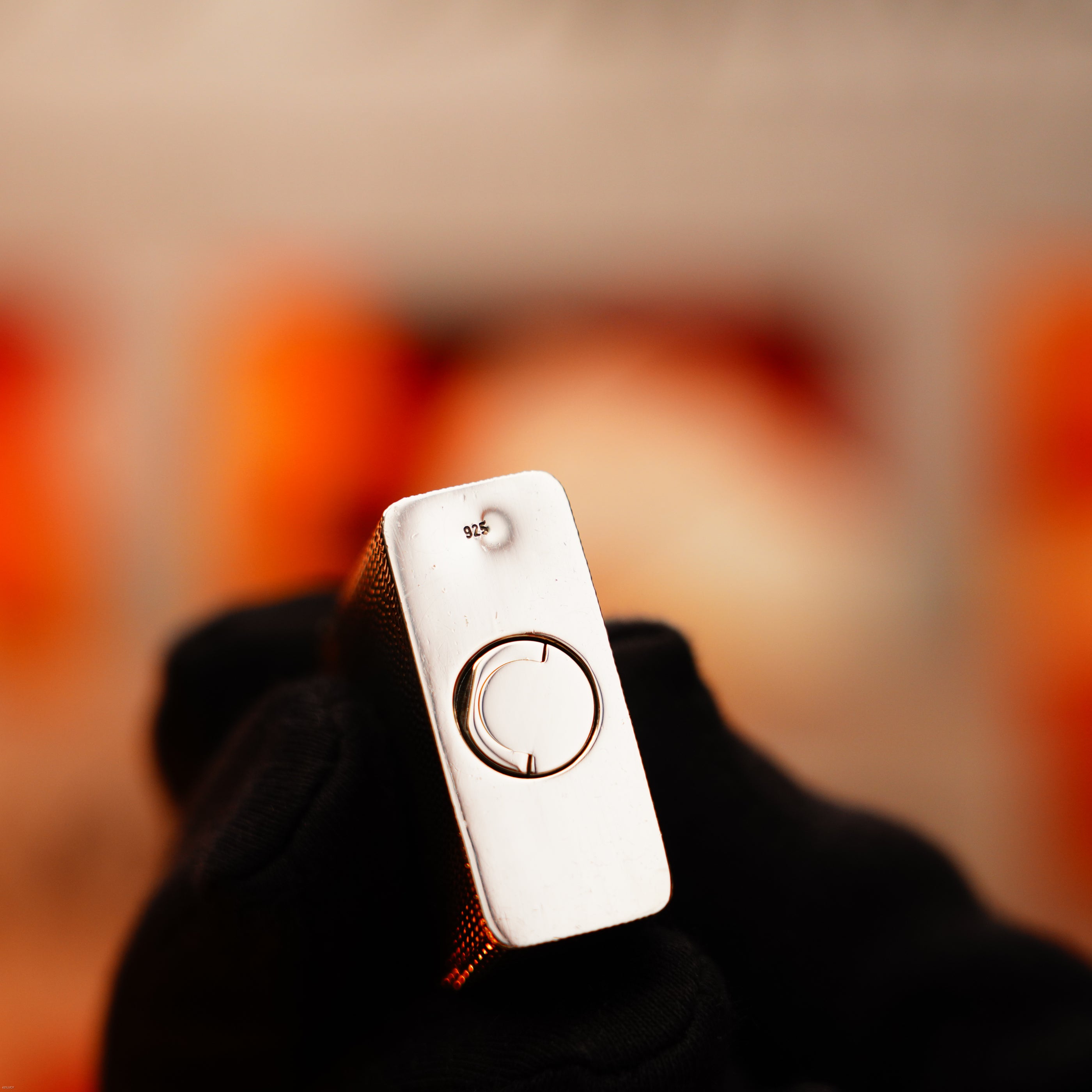 A gloved hand holds a Lucy Lighter—Vintage 1970 Extremely Rare 1/1 De St Dupont Solid 925 Sterling Ligne 1 Guilloché Pattern Lighter—its silver body, stamped "925," and circular ring exude vintage luxury appeal.