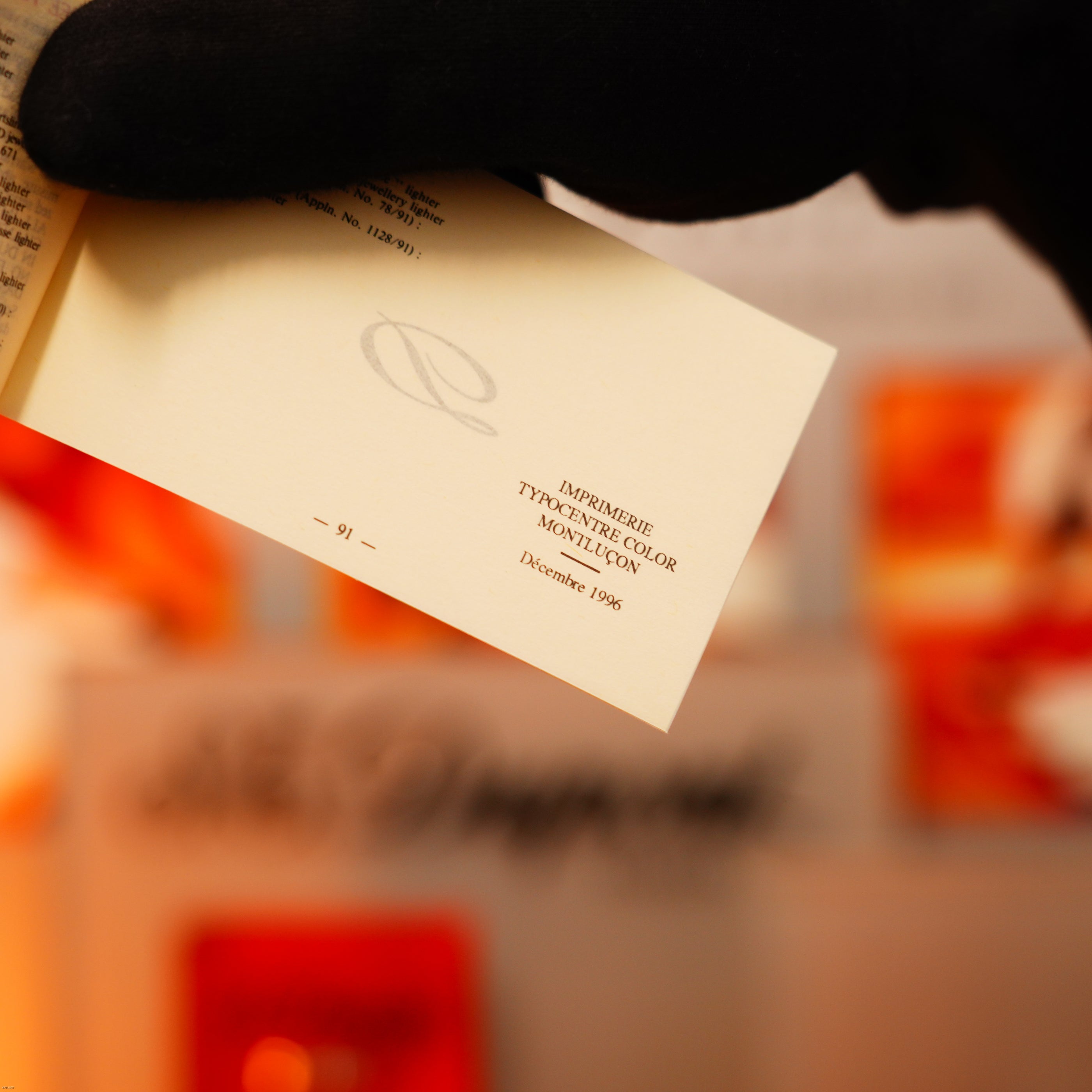 A gloved hand opens a book to “IMPRIMERIE TYPOFRANCE COLOR MONTLUCON Décembre 1995” (page 91), recalling the timeless allure of the Vintage 1970 Extremely Rare De St Dupont Solid 925 Sterling Lighter by Lucy Lighter.