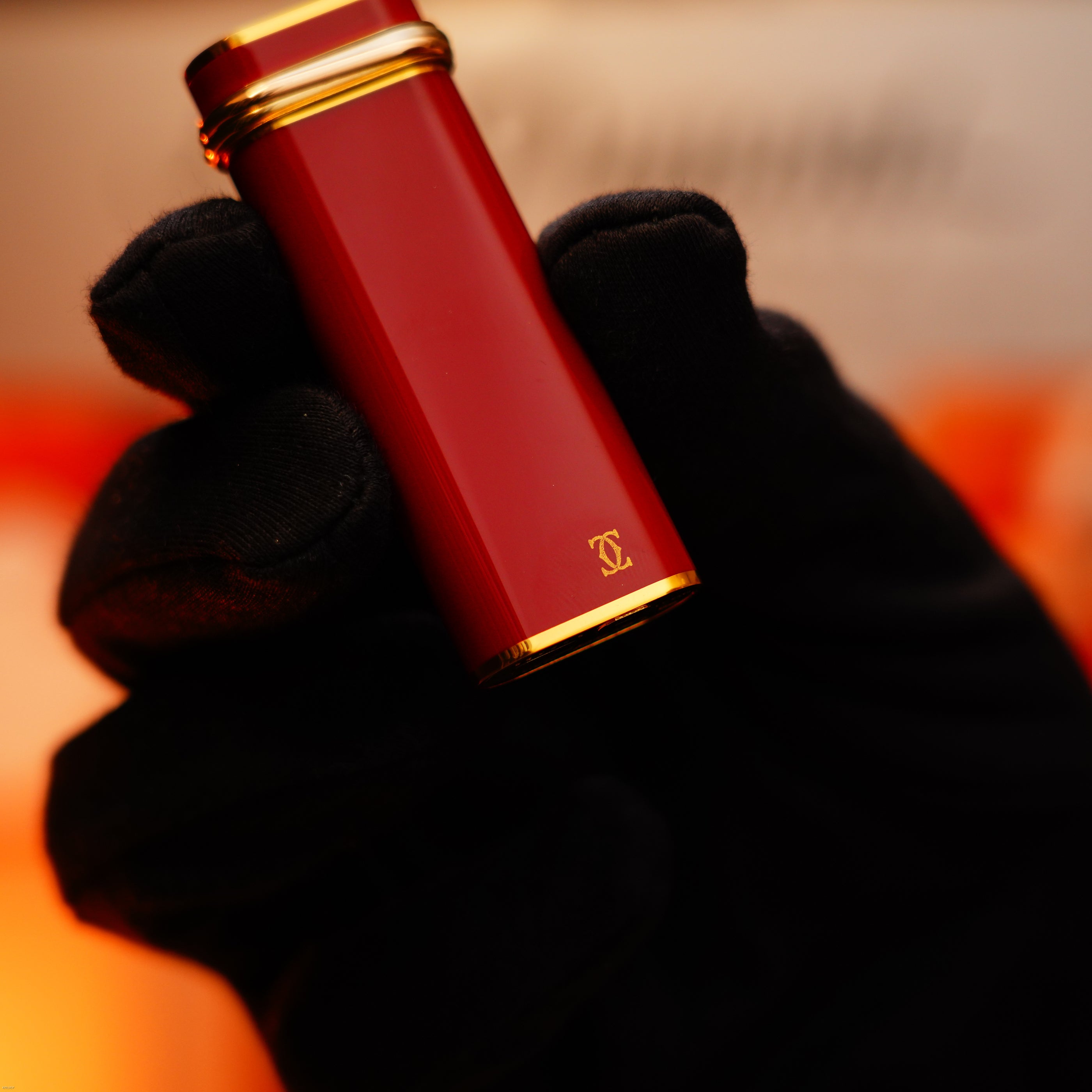 A gloved hand holds a Vintage 1970 Early Cartier Production Heavy Silver Finish Rare Guilloché Pattern Lighter by Lucy Lighter, showcasing elegant craftsmanship and timeless style.