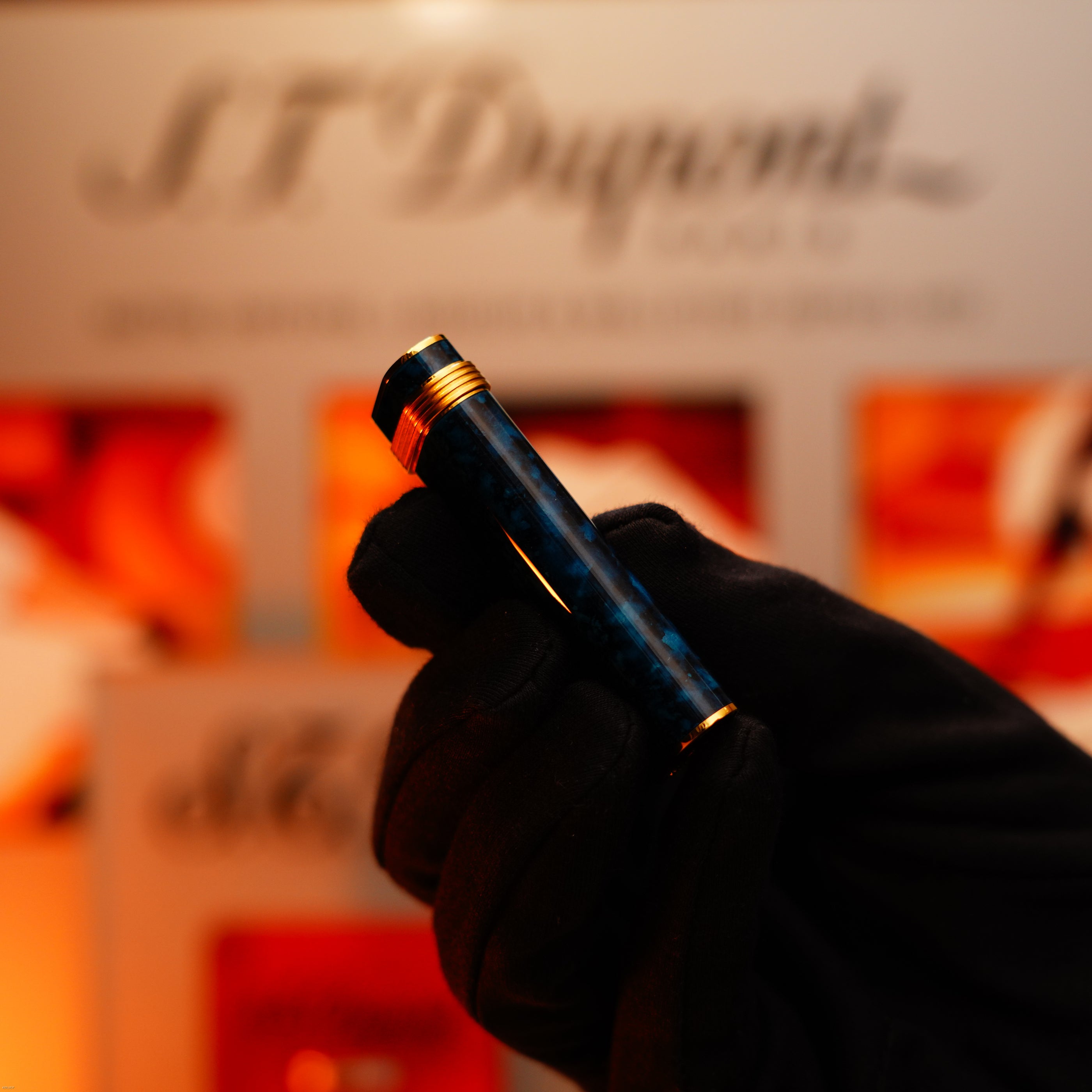 A gloved hand holds a Vintage 1980 Cartier Oval 24k Gold Finish Lapiz Lacquer with 18k Trinity Ring On Door Le Must Lighter by Lucy Lighter, reflecting the brand's commitment to quality and timeless elegance.