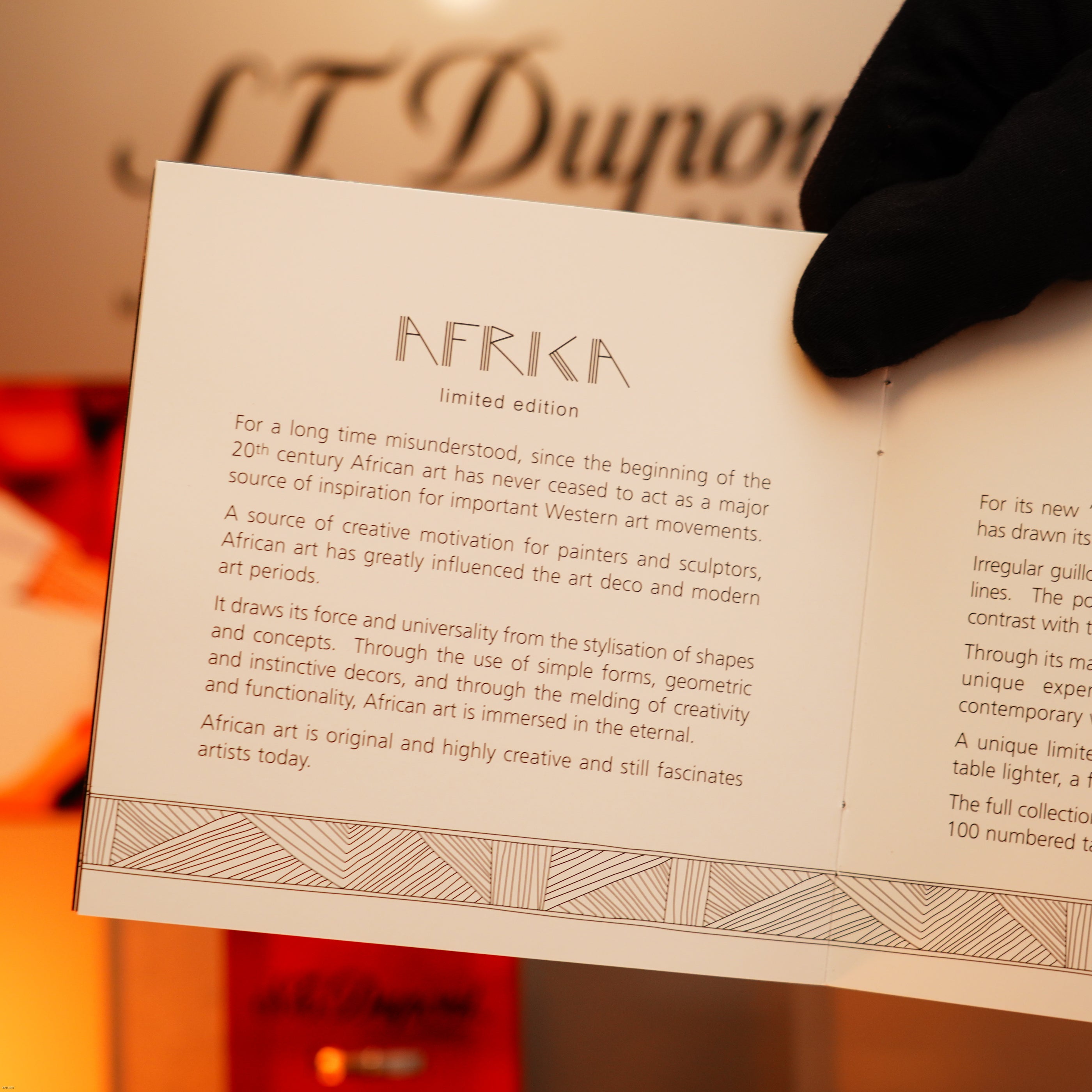 A gloved hand holds a "Vintage 2000 St Dupont Limited Edition Heavy 24k Gold Finish Africa Natural Lacquer Large Ligne 2 Lighter" by Lucy Lighter, symbolizing African creativity and luxury, with a quality guarantee and 12-month warranty.