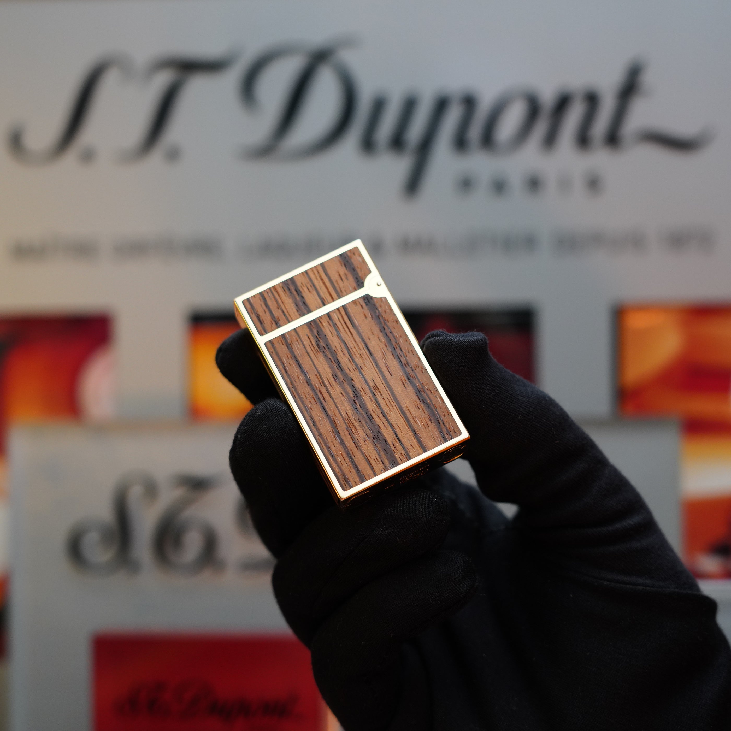 A gloved hand holds an extremely rare 1989 S.T. Dupont Real Wood no lacquer prototype Ligne 2 lighter, with the brand's logo and descriptive text in the background.