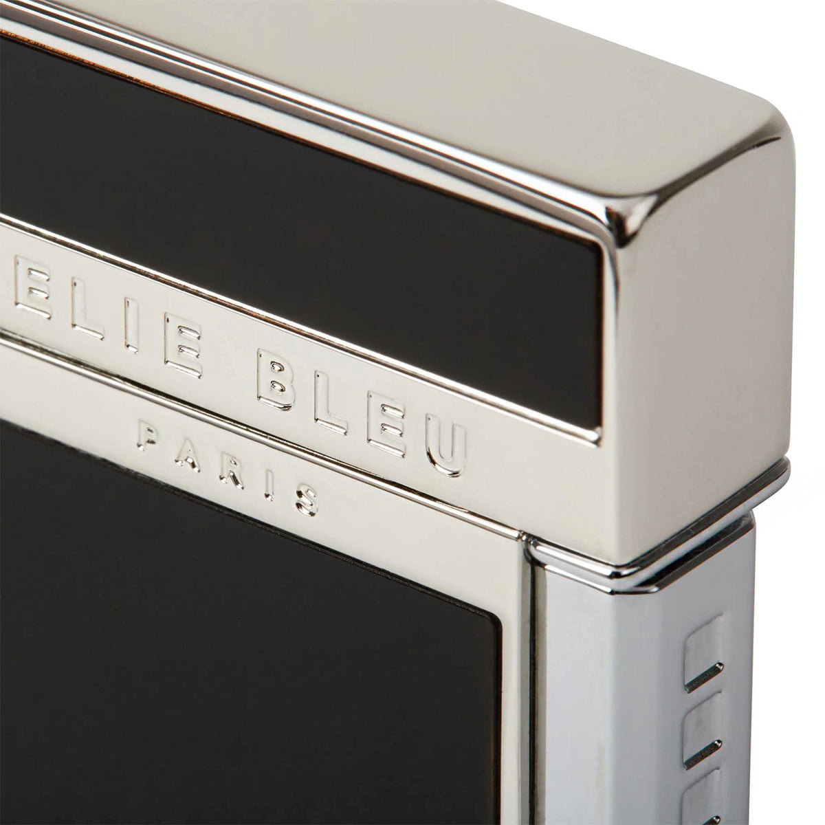 Close-up of a metallic silver Elie Bleu lighter with a black enamel panel and engraved branding on a white background.
