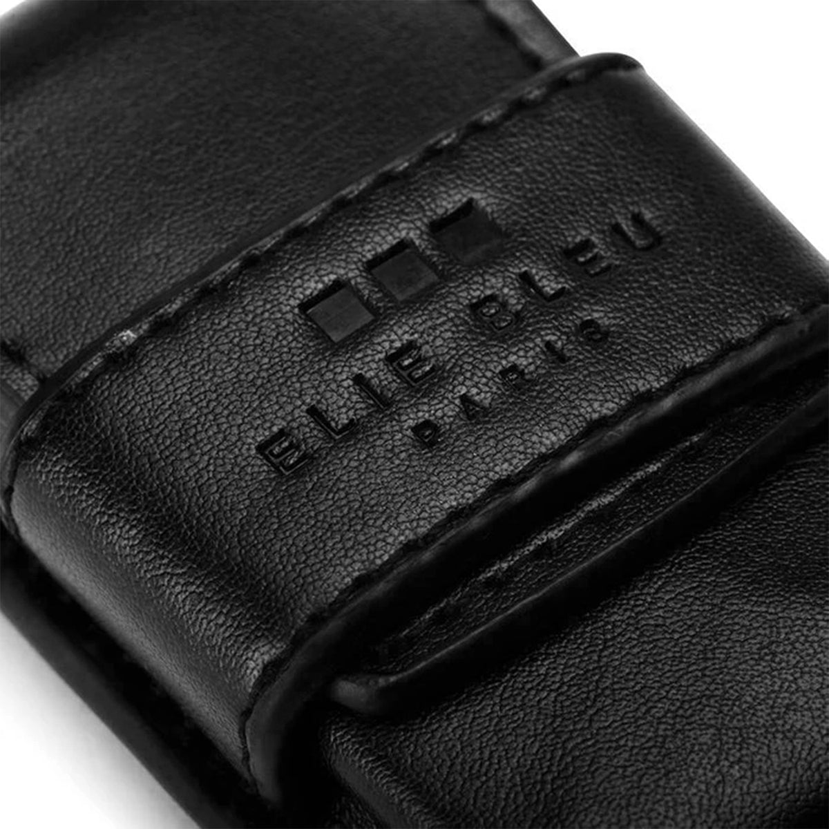 Close-up of a black textured leather strap with a debossed strap clasp featuring the brand name 'ELIE BLEU PARIS' and three small square marks, on a white background.