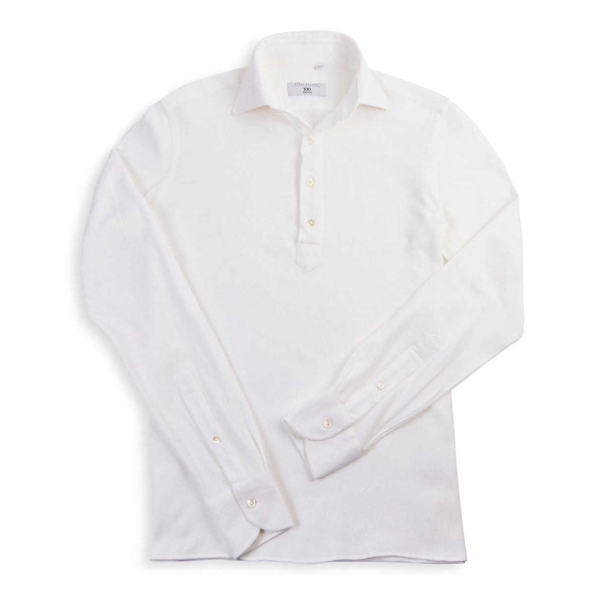 The 100 Hands x Kirby Allison White Long Sleeve Knit Polo from KirbyAllison.com is a high-quality, off-white dress shirt made from premium Cacciopoli jersey yarns, featuring a button-up collar and three-button placket.