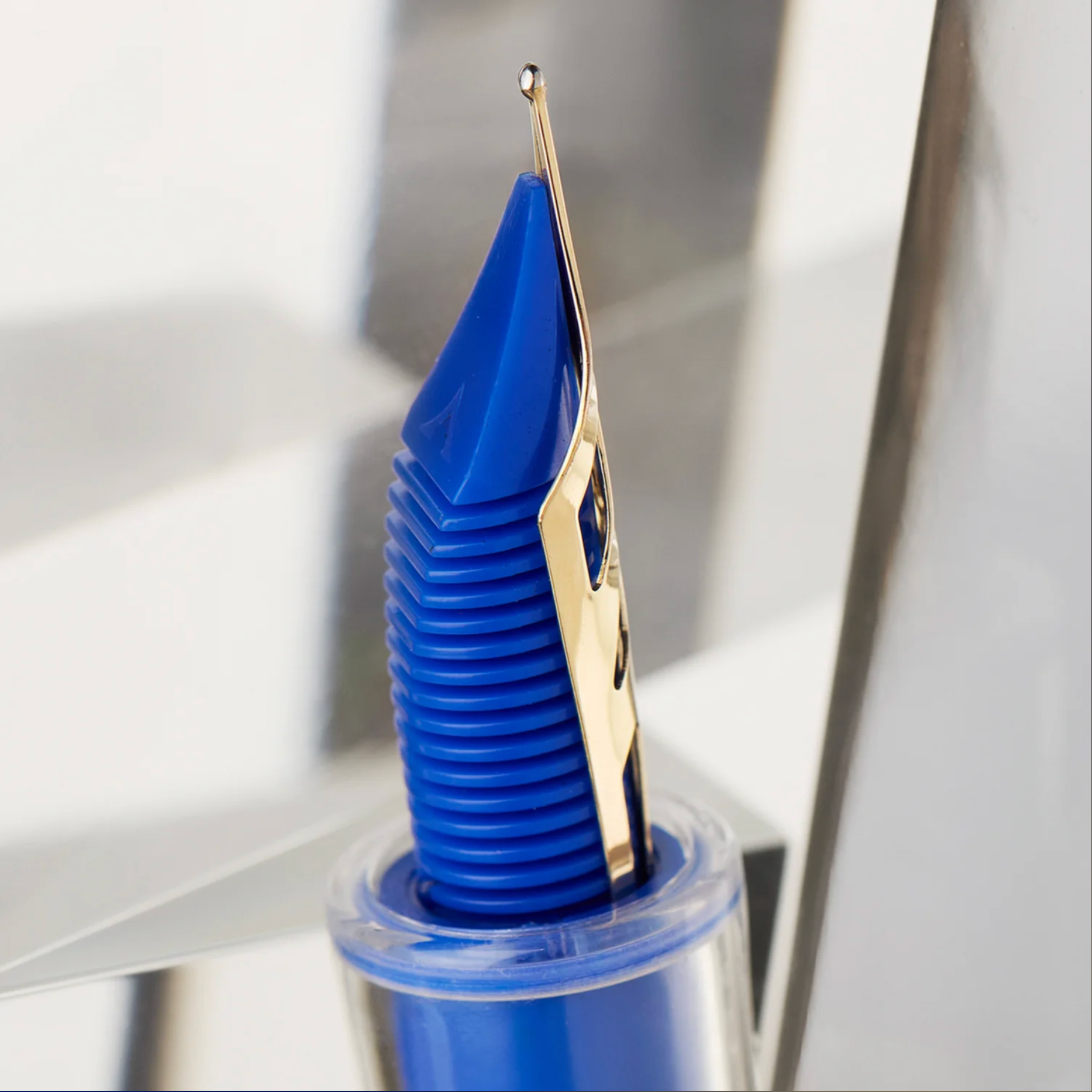 Blue pen with gold nib on a white background