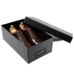 A pair of dark brown leather dress shoes with wooden shoe trees presented inside an open black shoebox on a white background.