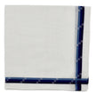 White linen pocket square with navy and light blue jacquard geometric border pattern on edges.