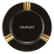 Black porcelain cigar ashtray with gold-plated accents and S.T. Dupont branding, viewed from above.