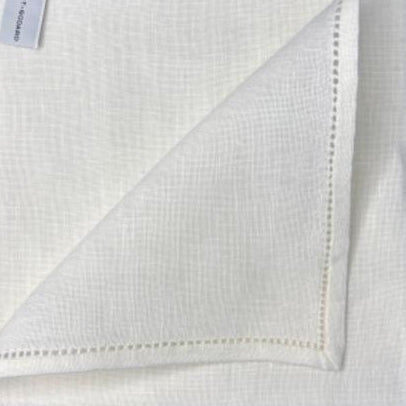 White linen pocket square with hemstitched edges and brand label visible.