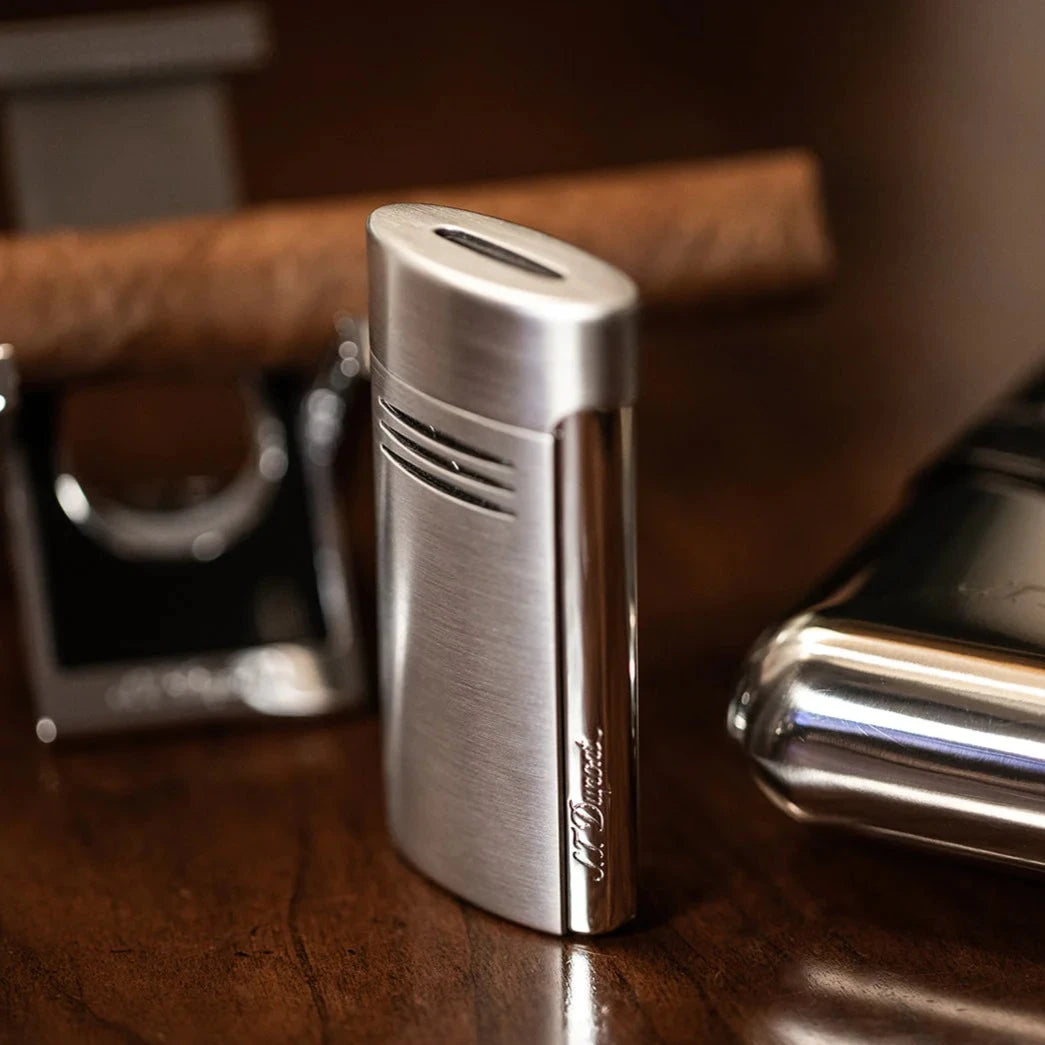 A S.T. Dupont Chrome Megajet lighter on a wooden table.