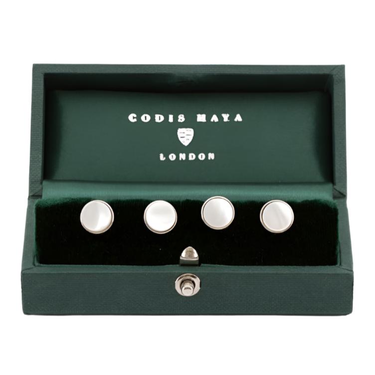 A set of Rhodium Plated Mother of Pearl Stud Set cufflinks in a green box from KirbyAllison.com.