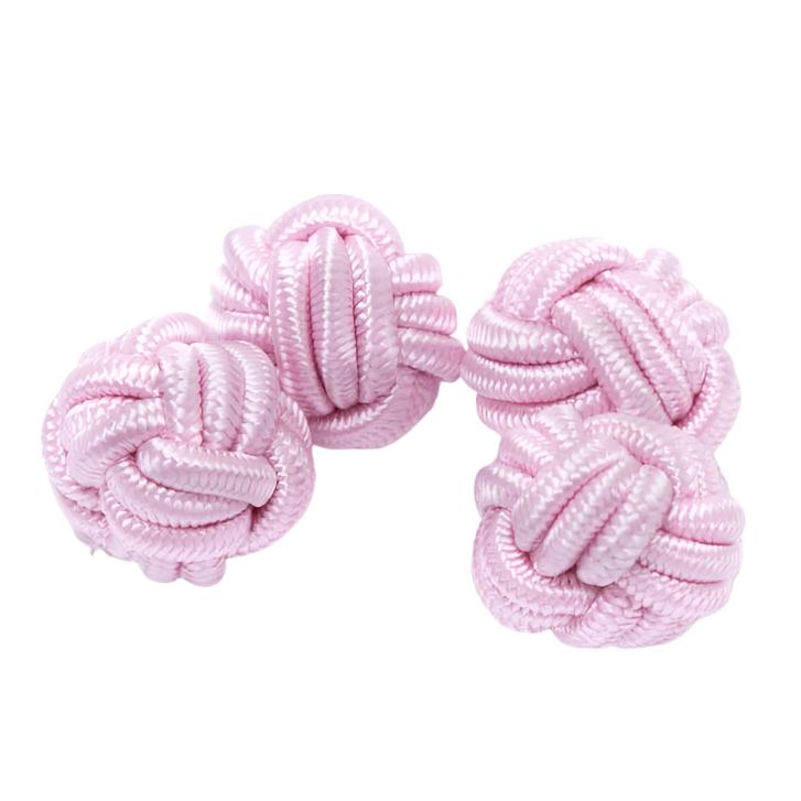 A group of handmade pink knotted Solid Knot Cuff Links by KirbyAllison.com on a white surface.