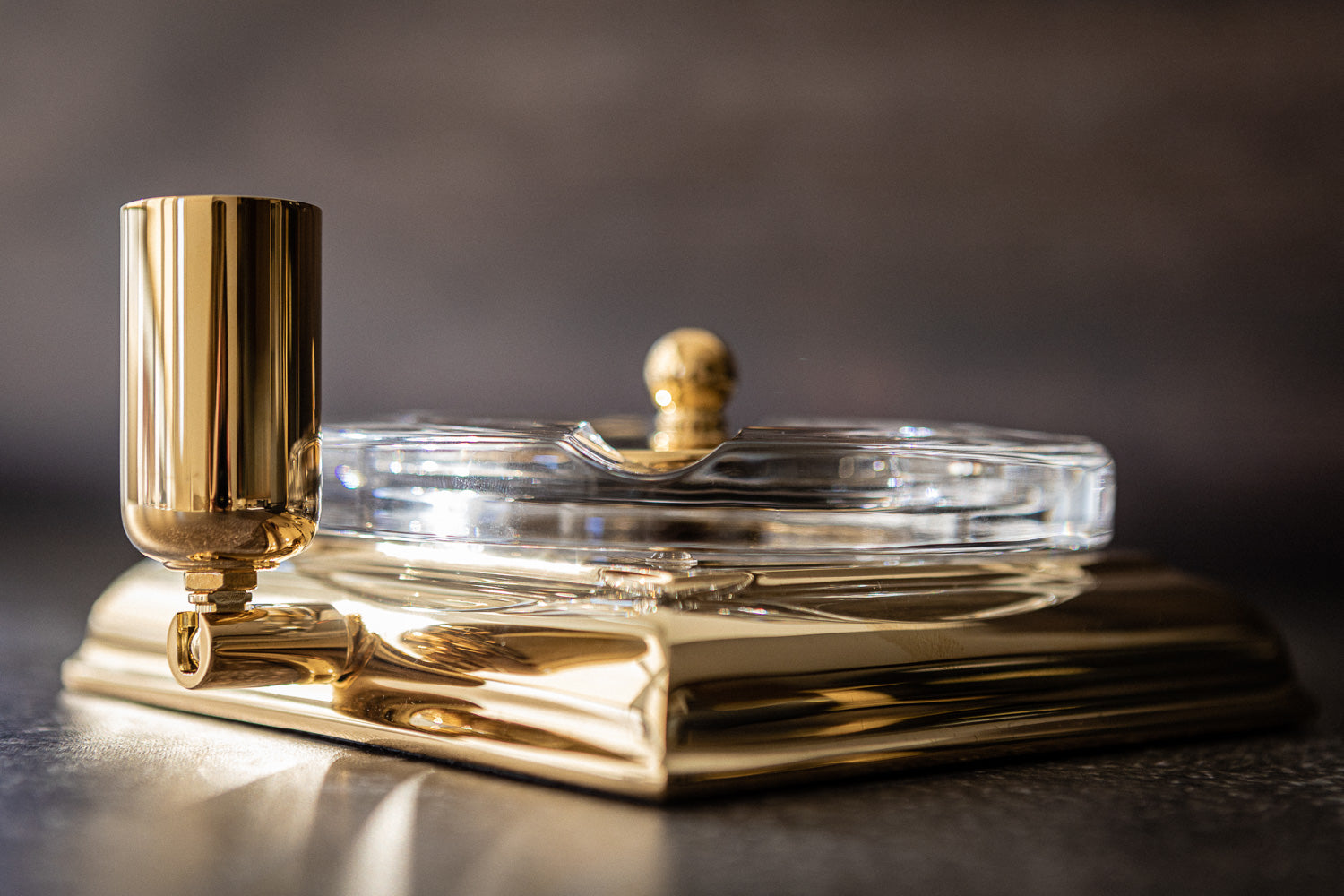 An El Casco Executive Cigar Ash Tray (Gold) on top of a table.