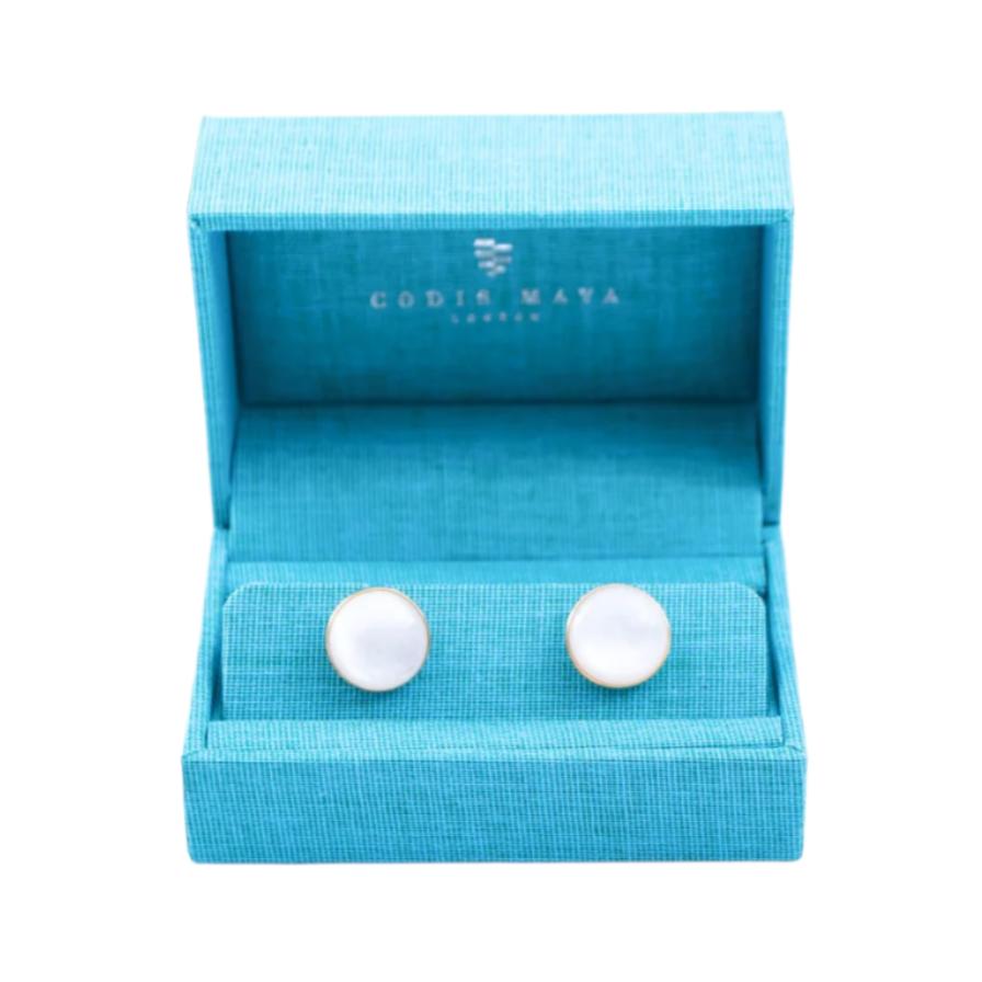 A pair of Indonesian Mother of Pearl Gold Stone Capsule Cufflinks from KirbyAllison.com in a blue box.