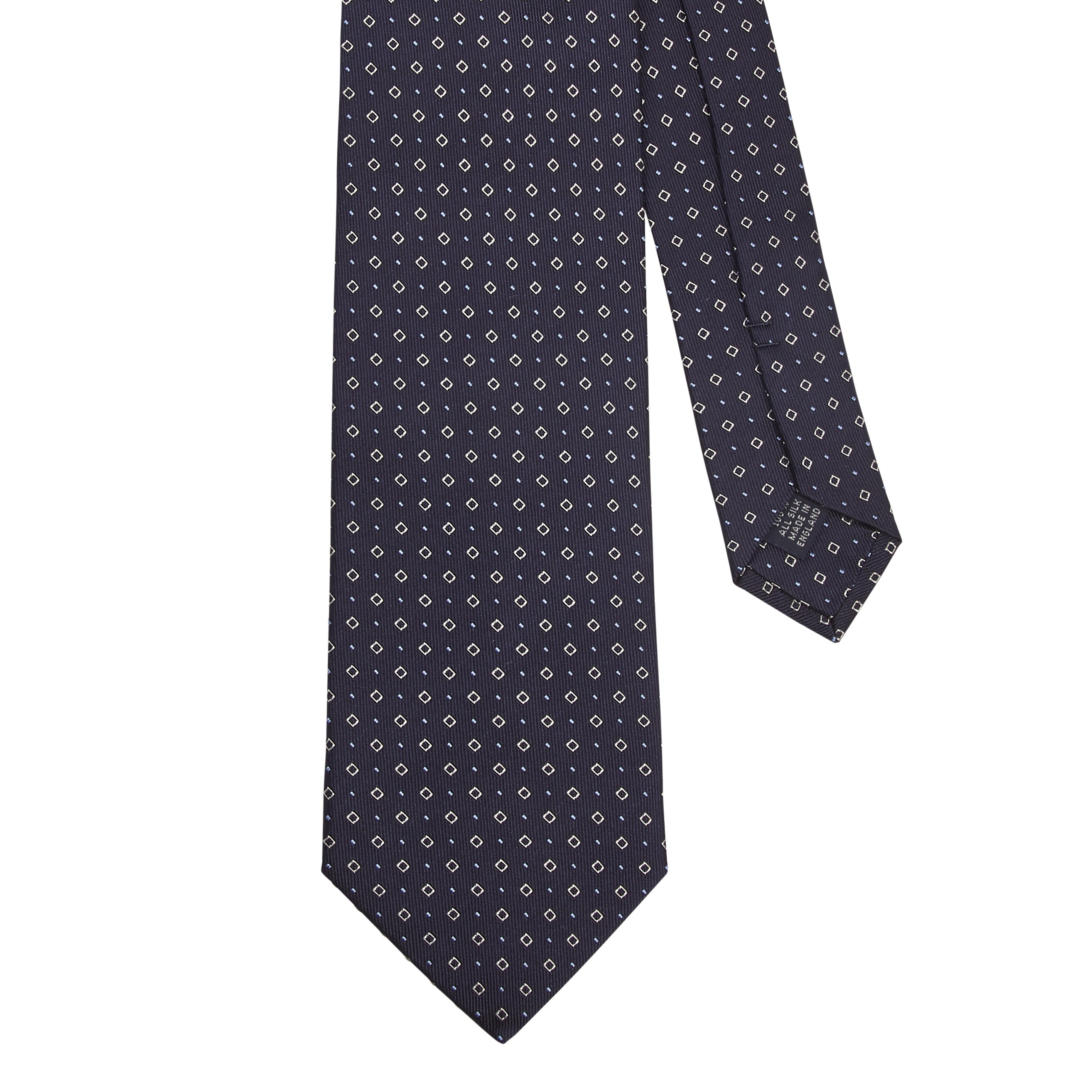 A handmade KirbyAllison.com Sovereign Grade Midnight Blue Alternating Square Dot Jacquard Tie with a black and white polka dot pattern.