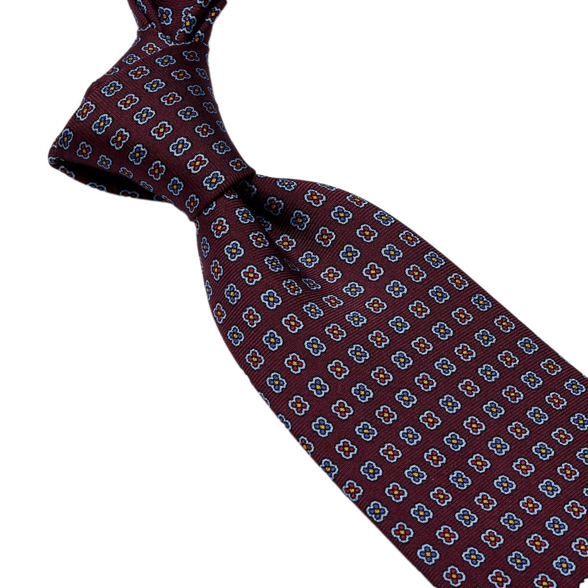 A Sovereign Grade Burgundy Daisy 36oz Printed Silk Tie with blue squares on it, crafted in the United Kingdom for quality, by KirbyAllison.com.