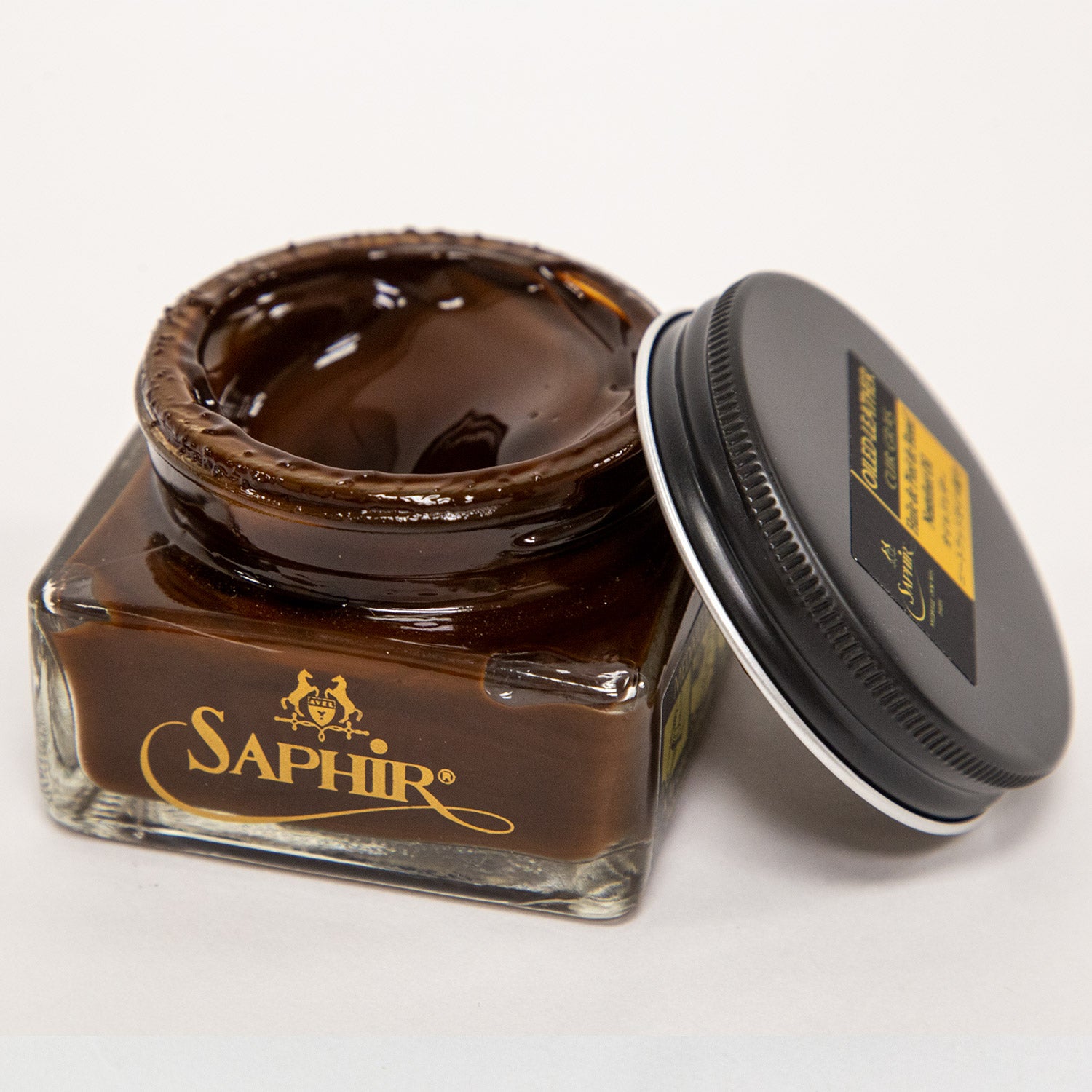 A jar of Saphir Medaille d'Or Oiled Leather Cream for Chromexcel made by KirbyAllison.com sitting on top of a white surface.