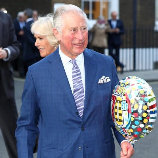 The duke and duchess of cambridge are holding balloons and wearing a Sovereign Grade Prince of Wales Pocket Square from KirbyAllison.com.