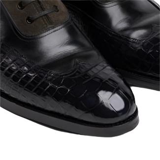 A pair of KirbyAllison.com High Shine Service black and brown crocodile boots on a white background.